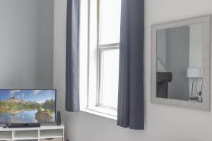 uma sala de estar com televisão e janela em OPP Plymouth - Large 3 bed, great WIFI and parking! BIG SAVINGS booking 7 nights or longer! em Plymouth