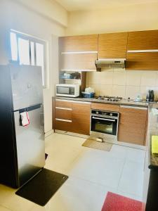 uma cozinha com um frigorífico e um micro-ondas em 3 Bedroom Apartment - Iconic Residences Colombo em Sri Jayewardenepur- Kotte