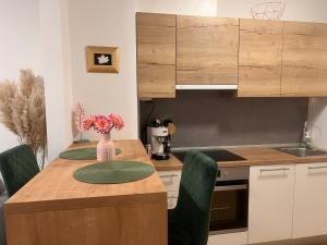 a kitchen with a table with a vase of flowers on it at LILY apartment - Flexible SelfCheckins 48- Luxury- Extra big terrace with jacuzzi in Zagreb