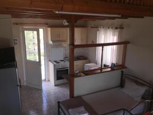 a small kitchen with a stove and a refrigerator at ΣΑΡΑΝΤΗΣ--ΚΩΣΤΑς in Lakíthra