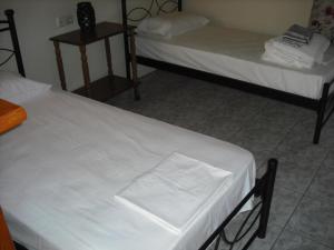 Lakíthra的住宿－Kostas--Sarantis--2，配有白色床单的客房内的两张床