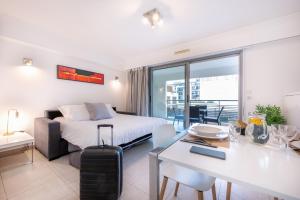 Habitación de hotel con cama, mesa y comedor en Nemea Appart Hotel Le Lido Cagnes sur Mer en Cagnes-sur-Mer