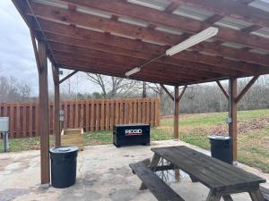 a wooden pavilion with a picnic table and a trash can at The Best Buffalo River RV Campsite in Hasty