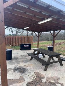 a wooden picnic table under a wooden pergola at The Best Buffalo River RV Campsite in Hasty