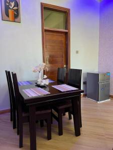 uma mesa de jantar com cadeiras e um frigorífico em Dodoma furnished Apartment em Dodoma