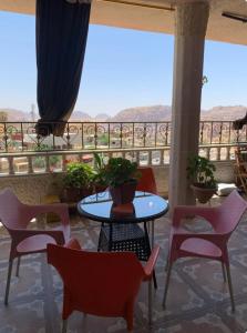 a patio with a table and chairs and a balcony at Bedouin family home in Wadi Musa