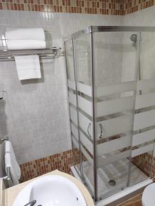 een badkamer met een toilet en een glazen douche bij HOTEL HACIENDA SANTA BARBARA in Castilleja de la Cuesta