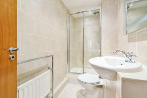 La salle de bains est pourvue de toilettes, d'un lavabo et d'une douche. dans l'établissement CENTRAL WEST END & THEATRE-LAND 2 Beds & 2 Baths, à Londres