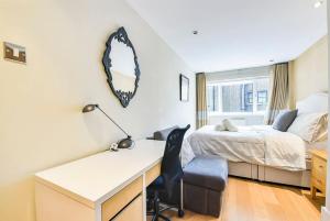 a bedroom with a bed and a desk with a desk at CENTRAL WEST END & THEATRE-LAND 2 Beds & 2 Baths in London