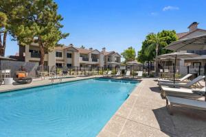 einen Pool mit Stühlen und Sonnenschirmen in einem Resort in der Unterkunft CozySuites TPC Scottsdale with parking, pool in Scottsdale