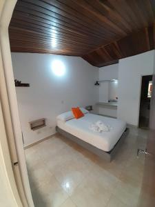 a bedroom with a bed with an orange pillow at Hotel Tame Real in Tame