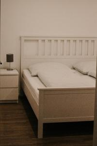 um quarto com uma cama branca e uma mesa de cabeceira em Ferienwohnung Ziegler em Ebersburg
