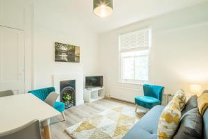 a living room with a couch and chairs and a fireplace at Cosy Two Bedroom Apartment in Excellent Location in Chesterton