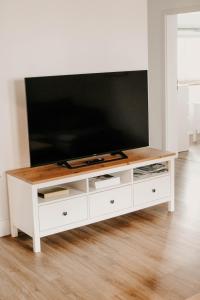 a white entertainment center with a flat screen tv on top at Ferienwohnung Ziegler in Ebersburg