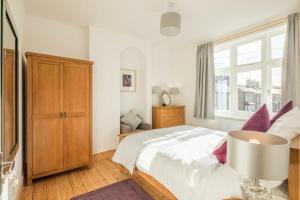 um quarto com uma cama grande e uma janela em Beautiful and Spacious Cambridge Home with Free Parking & Garden! em Cambridge