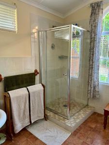 a shower with a glass door in a bathroom at Heritage Haven in Howick