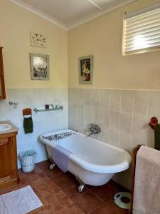 a bathroom with a tub and a sink at Heritage Haven in Howick +7 photos