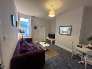 a living room with a purple couch and a table at 79 Hambledon-2Bed upstairs flat in Blythe