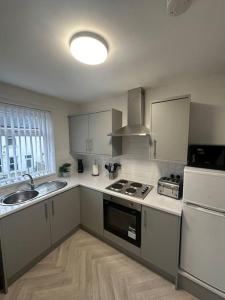 a kitchen with a sink and a stove top oven at 79 Hambledon-2Bed upstairs flat in Blythe