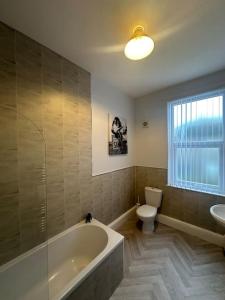 a bathroom with a tub and a toilet and a sink at 79 Hambledon-2Bed upstairs flat in Blythe