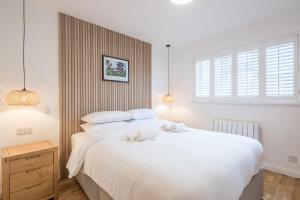 a bedroom with a large bed with two towels on it at Modern & Private - Free Parking in Cherry Hinton