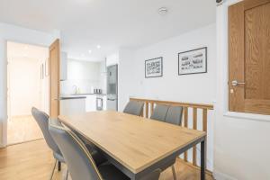 a kitchen and dining room with a wooden table and chairs at Modern & Private - Free Parking in Cherry Hinton