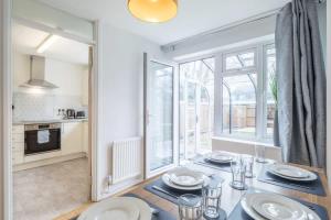 a dining room with a table and a large window at Charming Renovated Family Home in Cherry Hinton