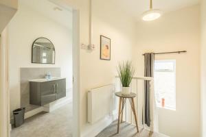 ein Badezimmer mit einem Waschbecken, einem Spiegel und einem Stuhl in der Unterkunft Fabulous Large Apartment for 7 - CENTRAL Cambridge in Cambridge