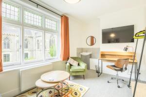 ein Wohnzimmer mit einem Schreibtisch und einem Stuhl in der Unterkunft Fabulous Large Apartment for 7 - CENTRAL Cambridge in Cambridge