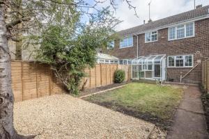 a brick house with a fence and a yard at Charming Renovated Family Home in Cherry Hinton