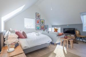 1 dormitorio con cama, sofá y TV en Luxury City Centre Flat with Stunning Water View, en Cambridge