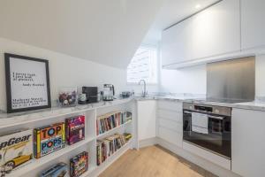a kitchen with white cabinets and a counter top at Luxury City Centre Flat with Stunning Water View in Cambridge