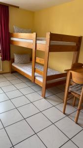2 Etagenbetten in einem Zimmer mit Fliesenboden in der Unterkunft Pension Chloe in Rust