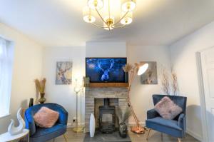 a living room with two blue chairs and a fireplace at Rest on Super-King Bed under The Starry Night in Chesterton