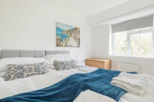 a bedroom with a bed with a blue blanket on it at Beautiful Family Home - Near River Cam in Cambridge