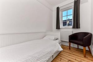 um quarto com uma cama, uma cadeira e uma janela em Beautiful Family Victorian Home em Crystal Palace