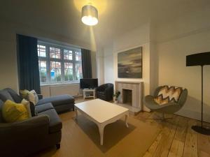 uma sala de estar com um sofá e uma mesa em Beautiful Family Victorian Home em Crystal Palace