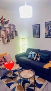 sala de estar con sofá verde y 2 mesas en Cosy T2 à 5 minutes de Metro 12-Proche Paris-Stade de France, en Aubervilliers