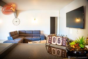 ein Wohnzimmer mit einem Sofa und einem Schild auf dem Tisch in der Unterkunft Grande Villa avec Piscine, jacuzzi, billard, baby-foot, 5 chambres, 11 pers. max in Saint-Louis