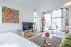 Schlafzimmer mit einem Bett, einem TV und einem Tisch in der Unterkunft Luxurious Central Apartment with Balcony in Cambridge