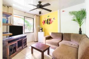 uma sala de estar com um sofá e uma televisão de ecrã plano em Casa Caribbean Coconut em Cahuita