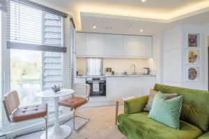 een woonkamer met een groene bank en een tafel bij Luxurious Central Apartment with Balcony in Cambridge