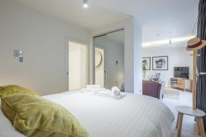 a bedroom with a white bed and a living room at Luxury City Centre Apartment in Cambridge