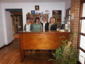 a group of people standing behind a bar at Paradiso Hotel in Merlo