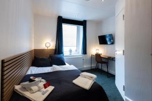 Schlafzimmer mit einem Bett, einem Schreibtisch und einem Fenster in der Unterkunft Milling Hotel Mini 19 in Odense