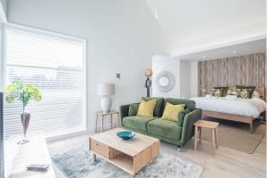 a living room with a green couch and a bed at Luxurious City Centre Apartment with Balcony in Cambridge