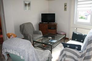 sala de estar con 2 sillas y TV en La maison de Tania en Neuve-Église