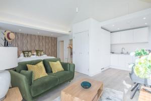 a living room with a green couch and a bed at Luxurious City Centre Apartment with Balcony in Cambridge