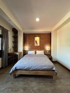 - une chambre avec un lit et un mur en briques dans l'établissement Shahi Studio Apartment, à Pātan