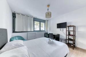 Schlafzimmer mit einem großen weißen Bett und einem Schreibtisch in der Unterkunft Studio Cosy Coeur Part Dieu in Lyon